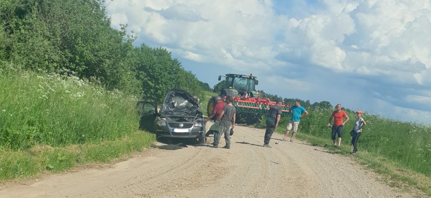 Traktorius su padargais taranavo automobilį